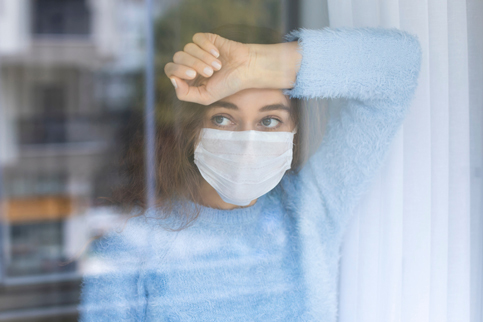 Woman in mask stressed about the challenges of behavioral health.